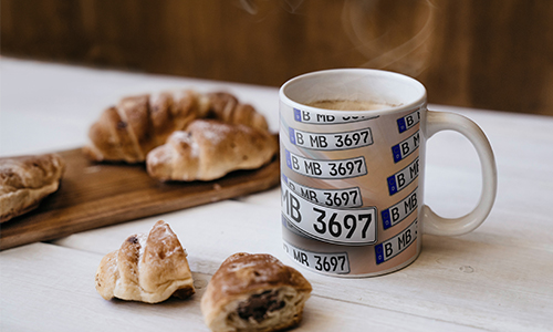 license plate mug with coffee and croissants