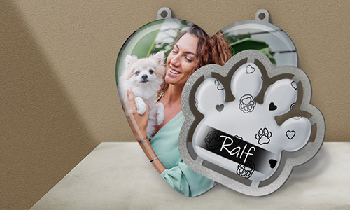 Heart-shaped dog photo tag and silver paw tag labeled “Ralf” — personalized pet ornaments with decorative patterns.