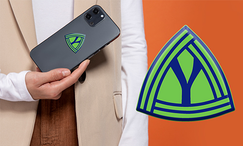 Person holding smartphone with personalized green-blue triangle logo — matching emblem displayed on orange background.
