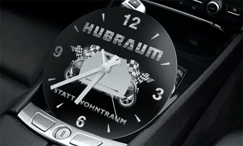 Racing-themed clock in car console with two cars, checkered flags, and HUBRAUM STATT WOHNTRAUM text