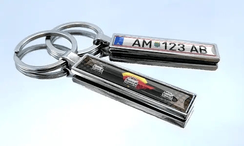 Metal comic keychain with car design and license plate detail