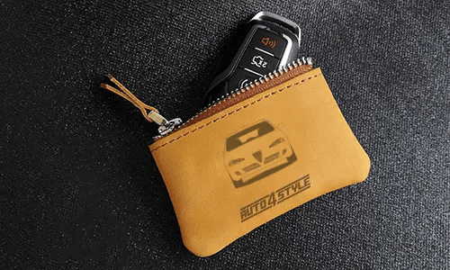 Two brown leather key pouches with zippers: one with motorcycle and plate 