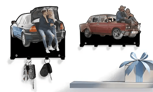 Zwei personalisierte Schlüsselhalter: Paar im Kofferraum eines blau-schwarzen Autos, Paar auf der Motorhaube eines roten Oldtimers
