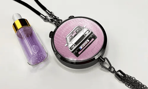 Pendant with pink background and white sports car, next to purple dropper bottle with gold cap