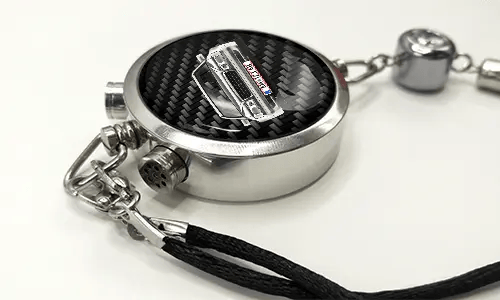 Round car key fob with carbon fiber face, buttons labeled LOCK and UNLOCK, braided black cord attached