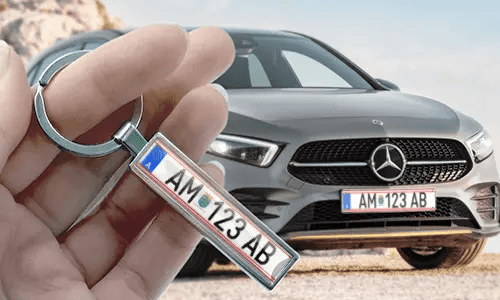 Porte-clés style plaque d’immatriculation comic tenu à la main avec la plaque de voiture correspondante en arrière-plan