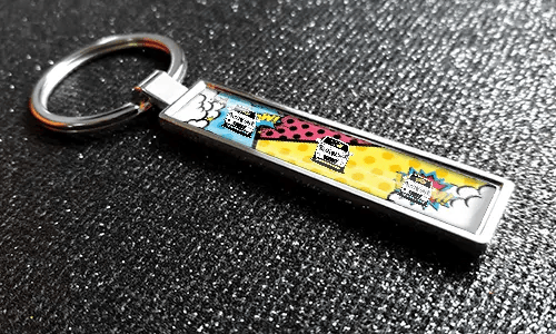 Porte-clés style bande dessinée avec plaque d’immatriculation et illustrations de voitures pop-art colorées sur une surface texturée