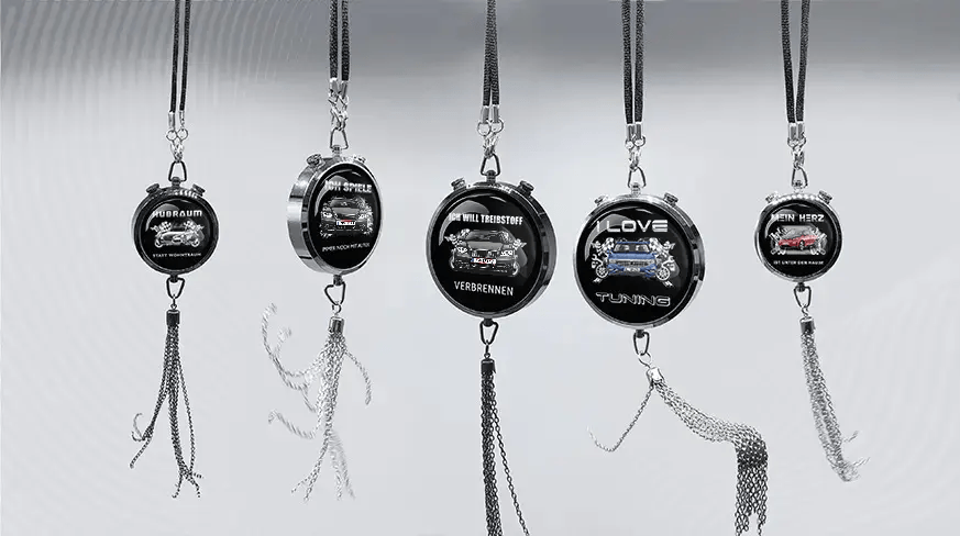 Five round keychains with German car-themed slogans and illustrations, hanging in a row