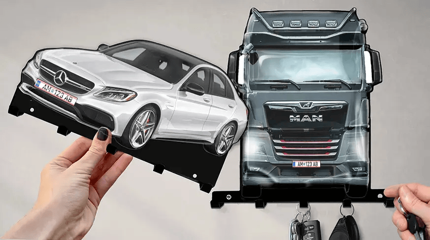 Wall-mounted key holder with detachable white Mercedes-Benz and black MAN truck shapes, each with hooks for keys